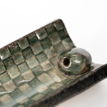 Close-up of the rounded stick insert and green mosaic glaze.