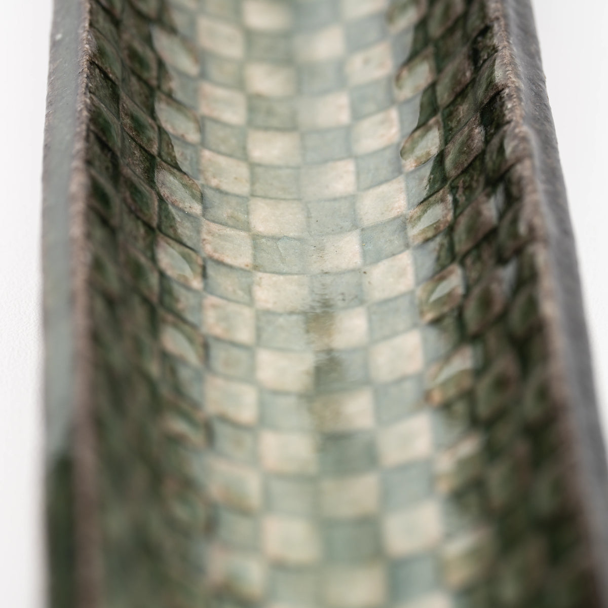 Close-up of green and cream squares inside the incense tray.