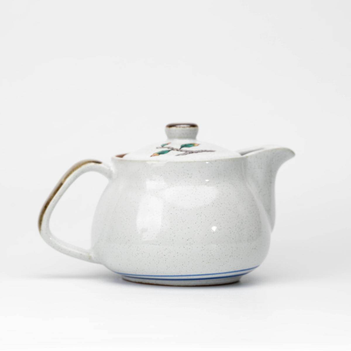 Back view of the Kutani owl teapot showing its pale glaze and blue foot lines.