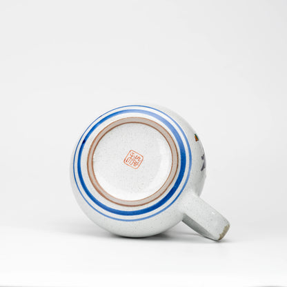 Underside of the Kutani owl teapot with a red maker's mark and blue rings.