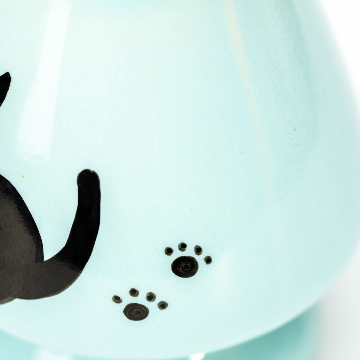 Small black paw prints beside the painted cat.