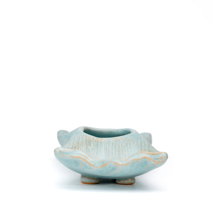 End view of the pale blue Hechimon vase showing its opening and rounded feet.