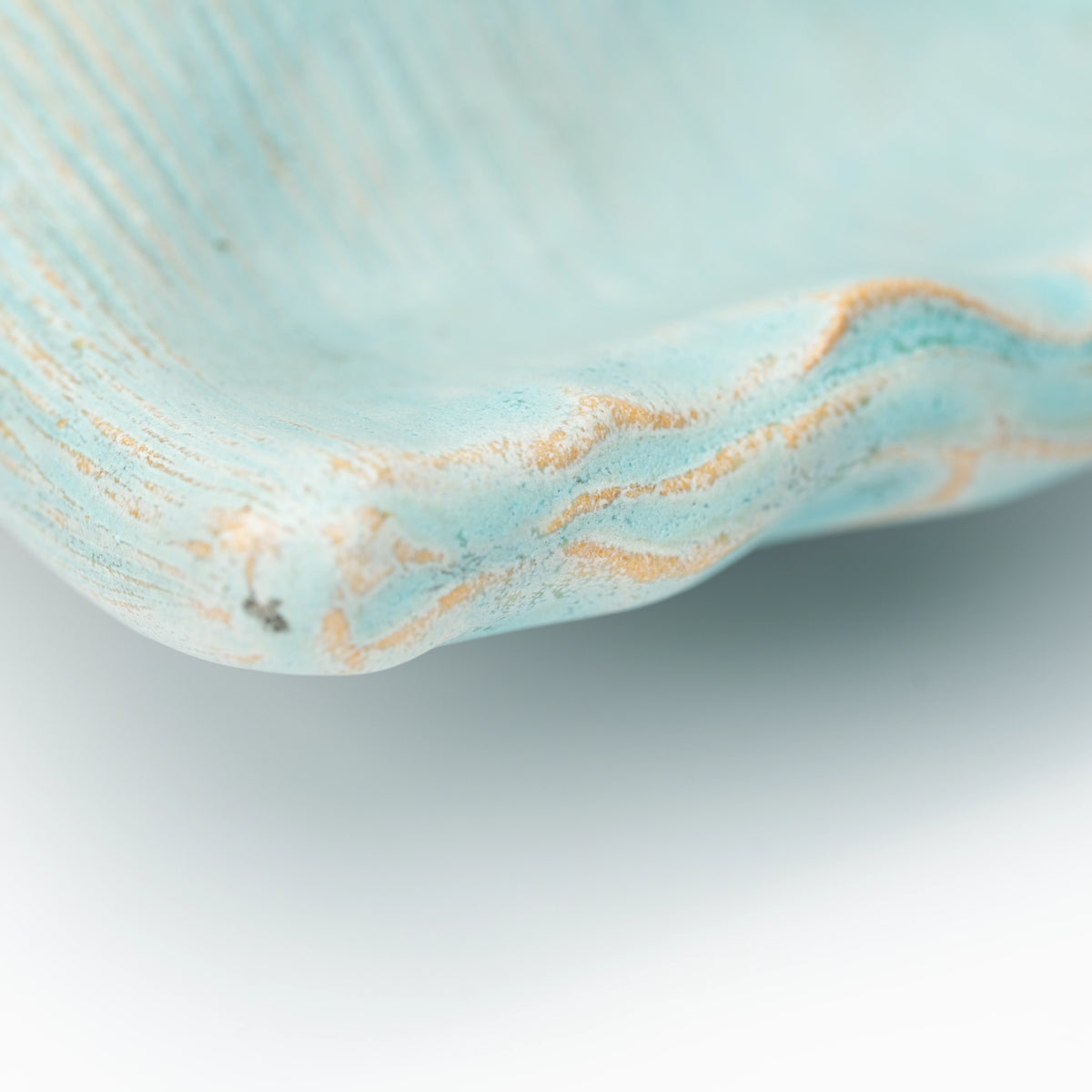 Close-up of the rippled rim and textured pale blue glaze.