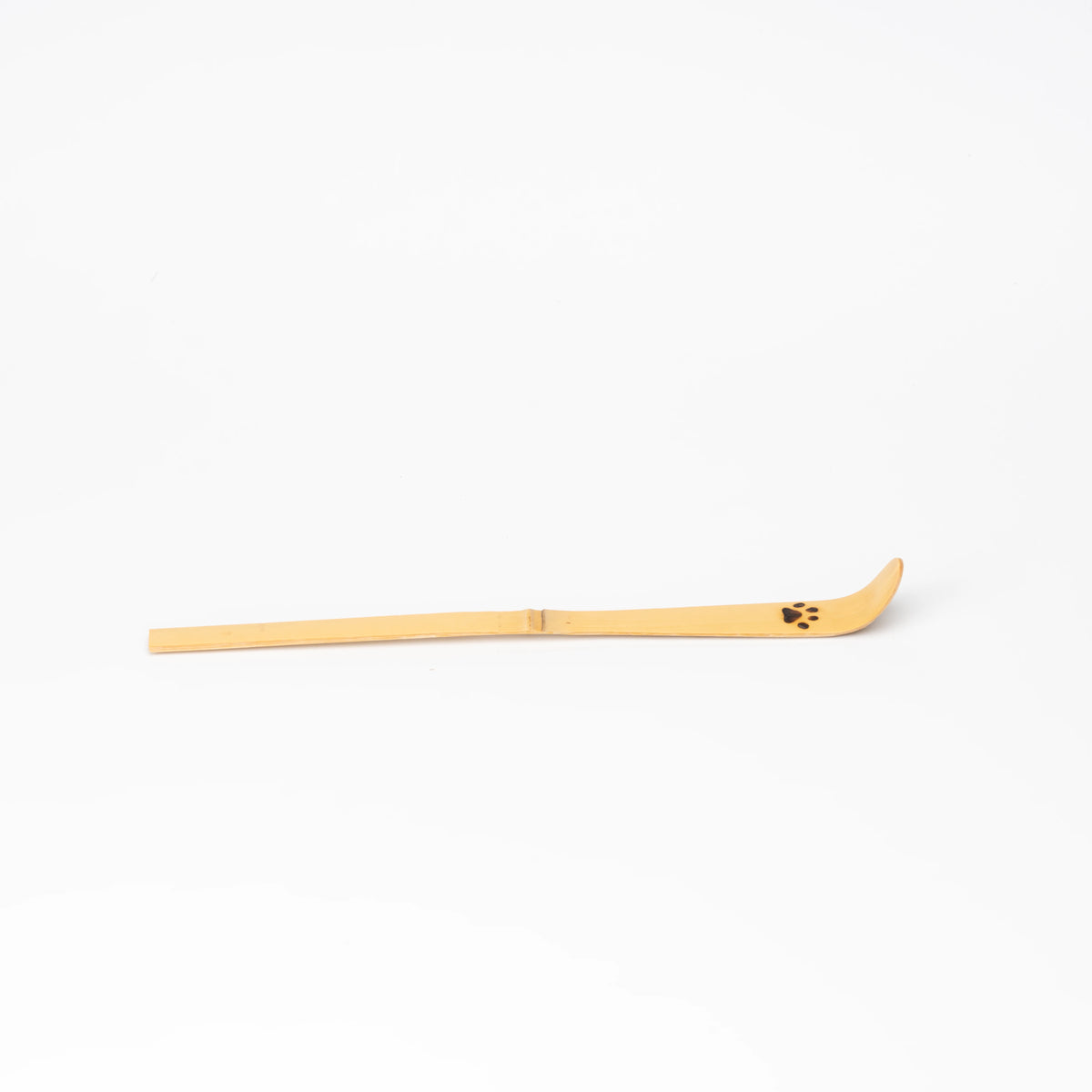 Side profile of the long bamboo scoop and raised curved tip.