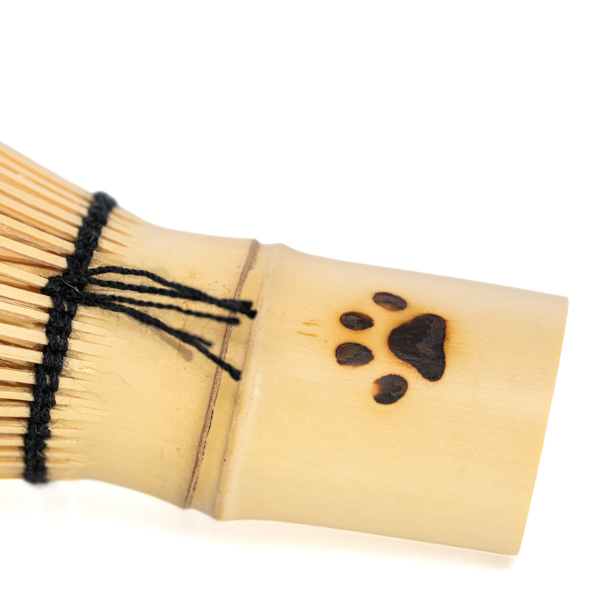 Close-up of the paw print and black thread around the bamboo handle.