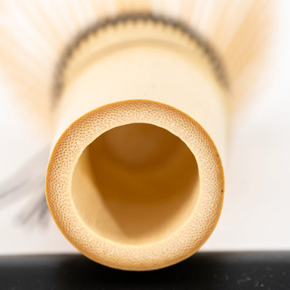 Circular hollow at the base of the bamboo whisk handle.