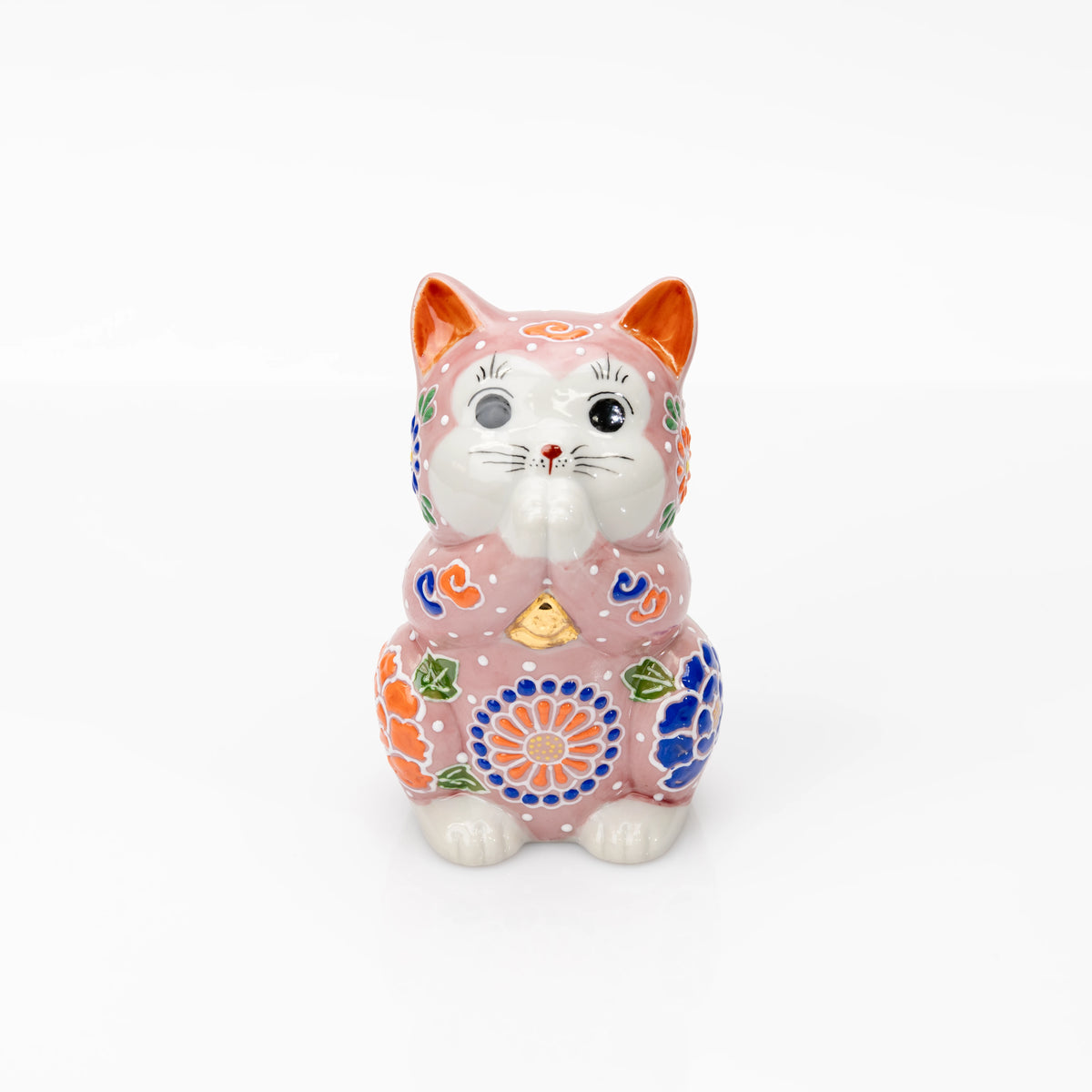 Pink Kutani praying cat with joined paws and colorful raised floral decoration on white.