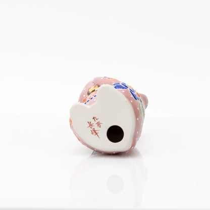 Underside of the pink ceramic cat, showing its round opening.