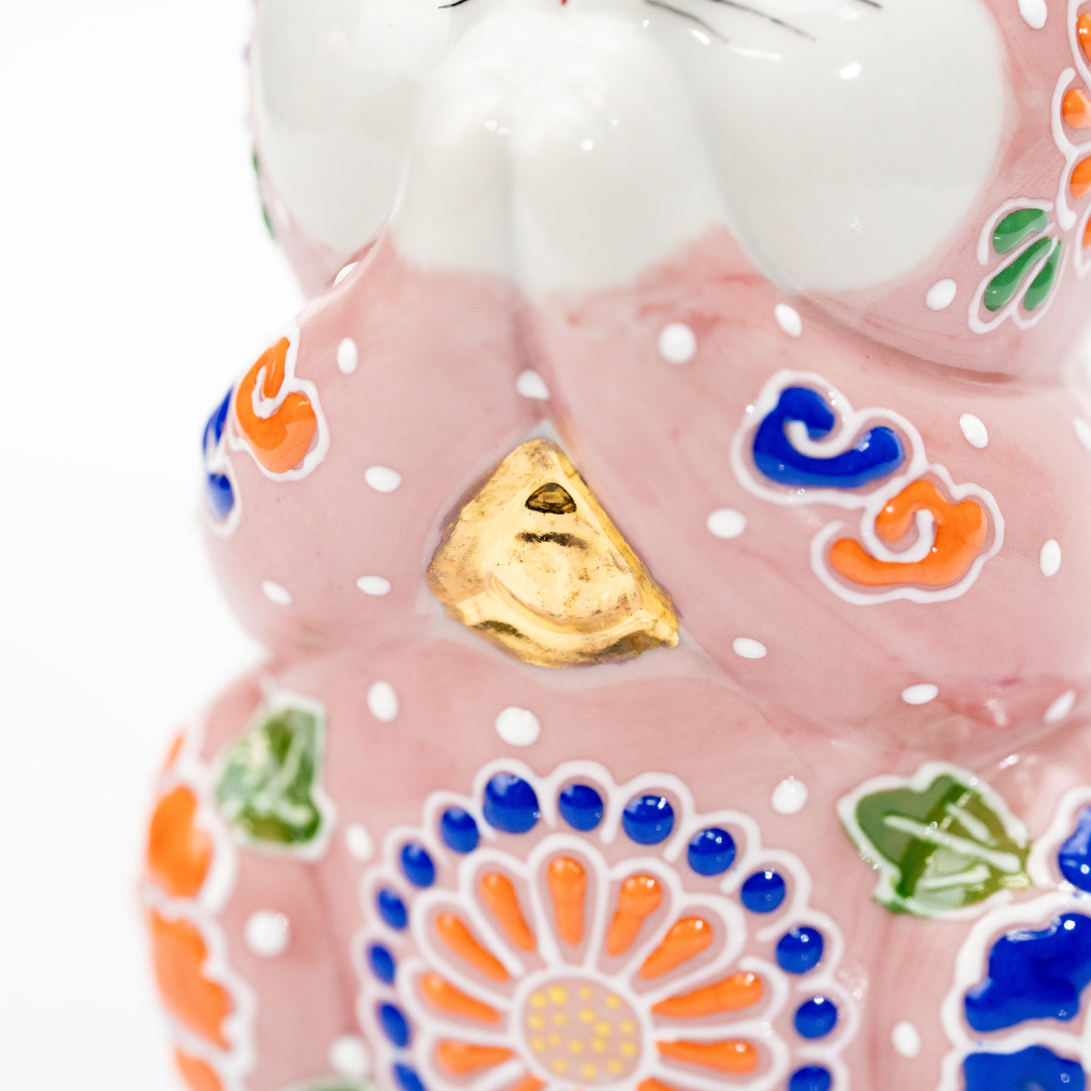 Gold bell and colorful flowers on the pink cat's chest.