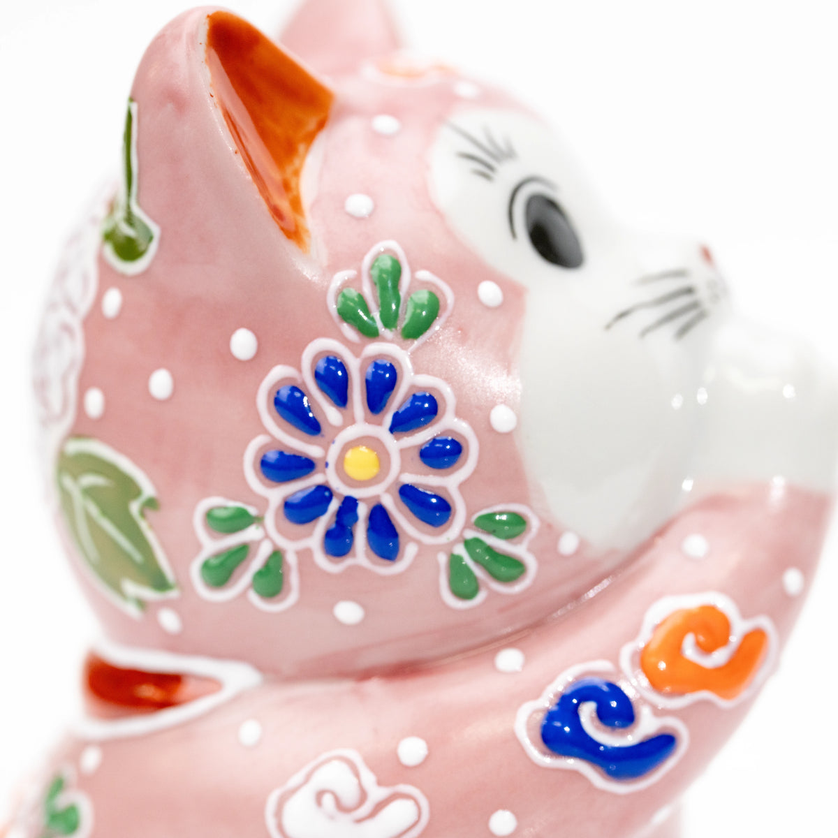 Close-up of the cat's side face and blue floral decoration.