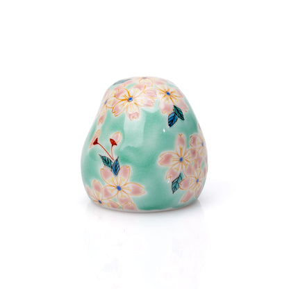 Back of the turquoise daruma with pink cherry blossoms.