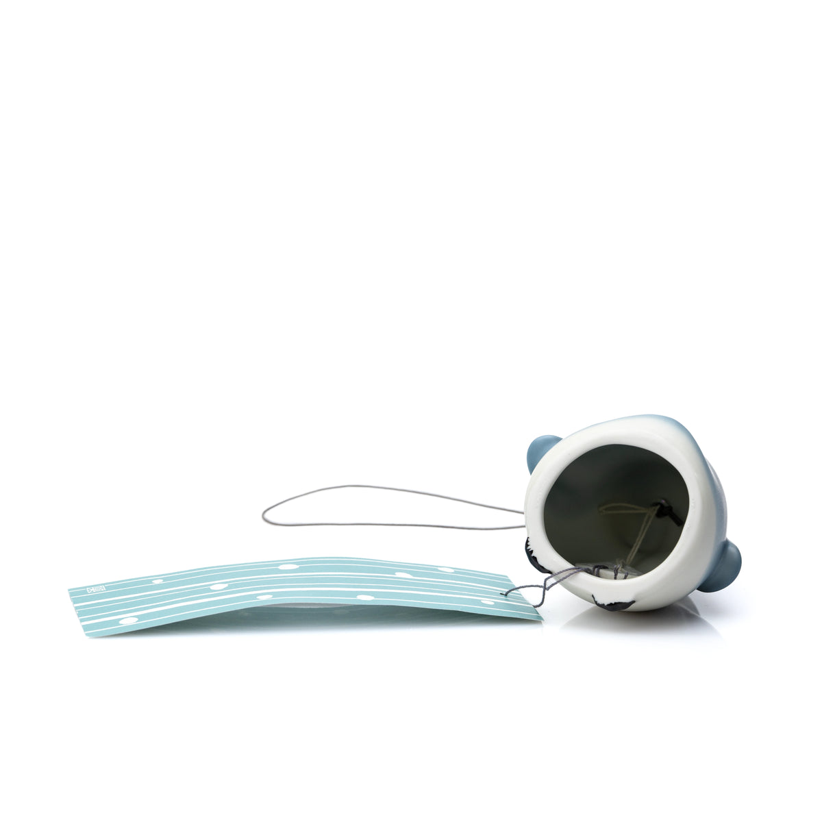 Open underside of the porcelain penguin wind chime and its hanging paper strip.