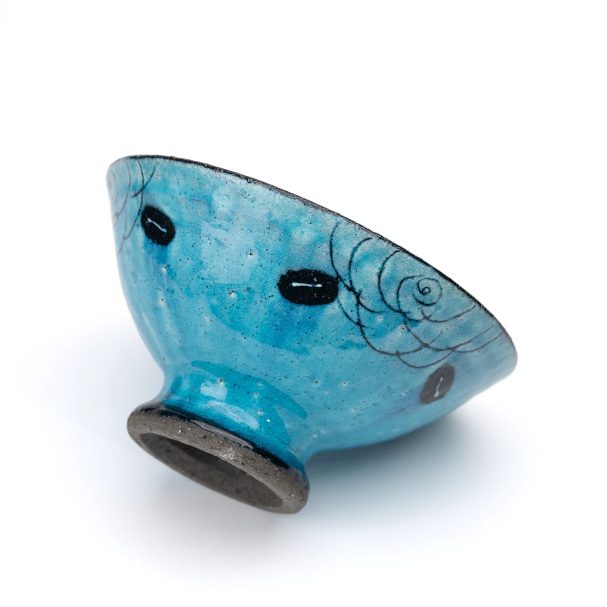 Side view of the turquoise footed dessert bowl and black foot.