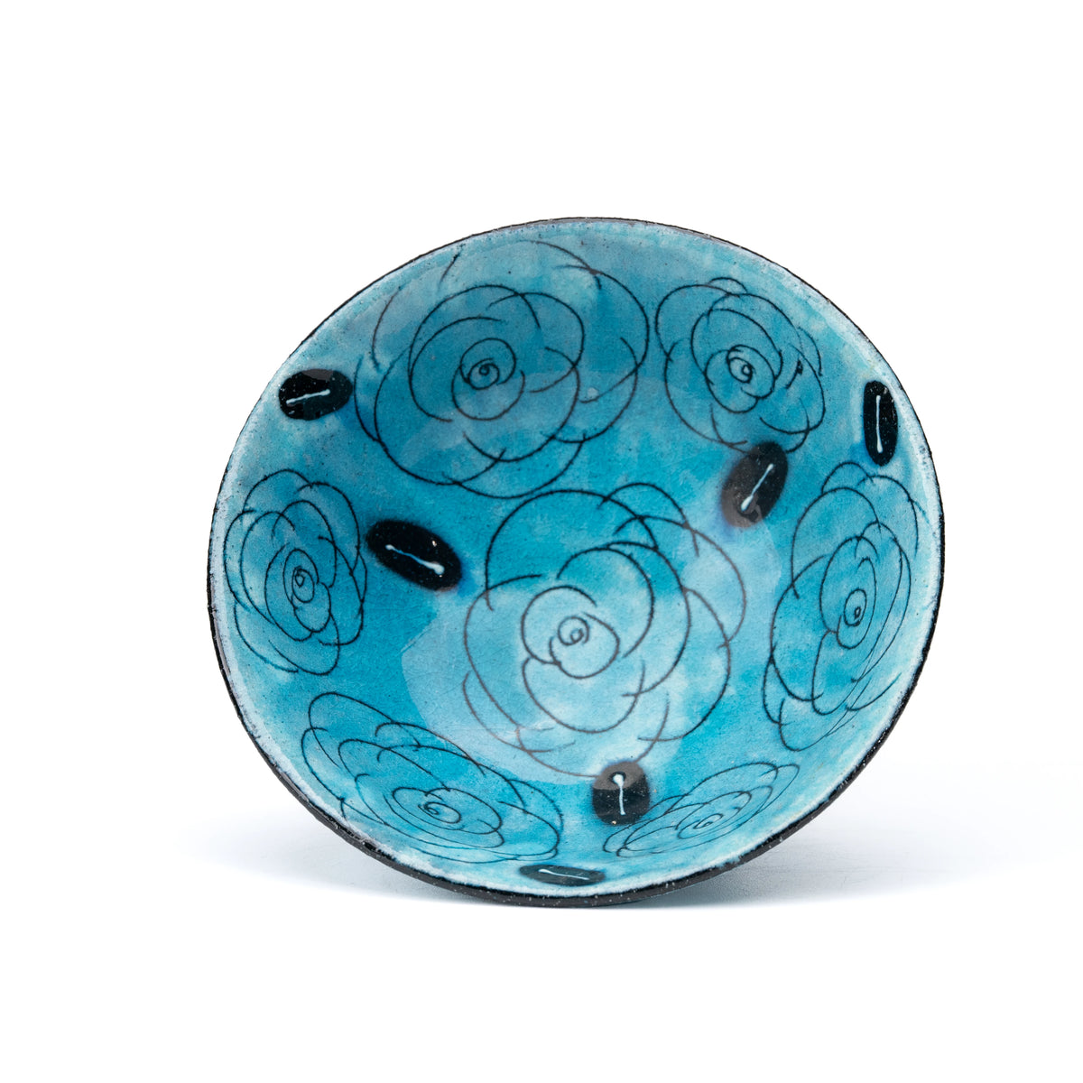 Overhead view of the turquoise dessert bowl with outlined roses.