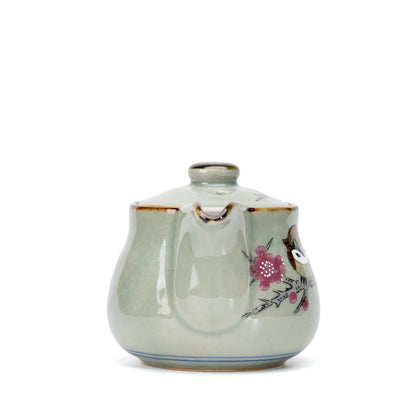 Front view of the spout and pink floral decoration on the teapot.