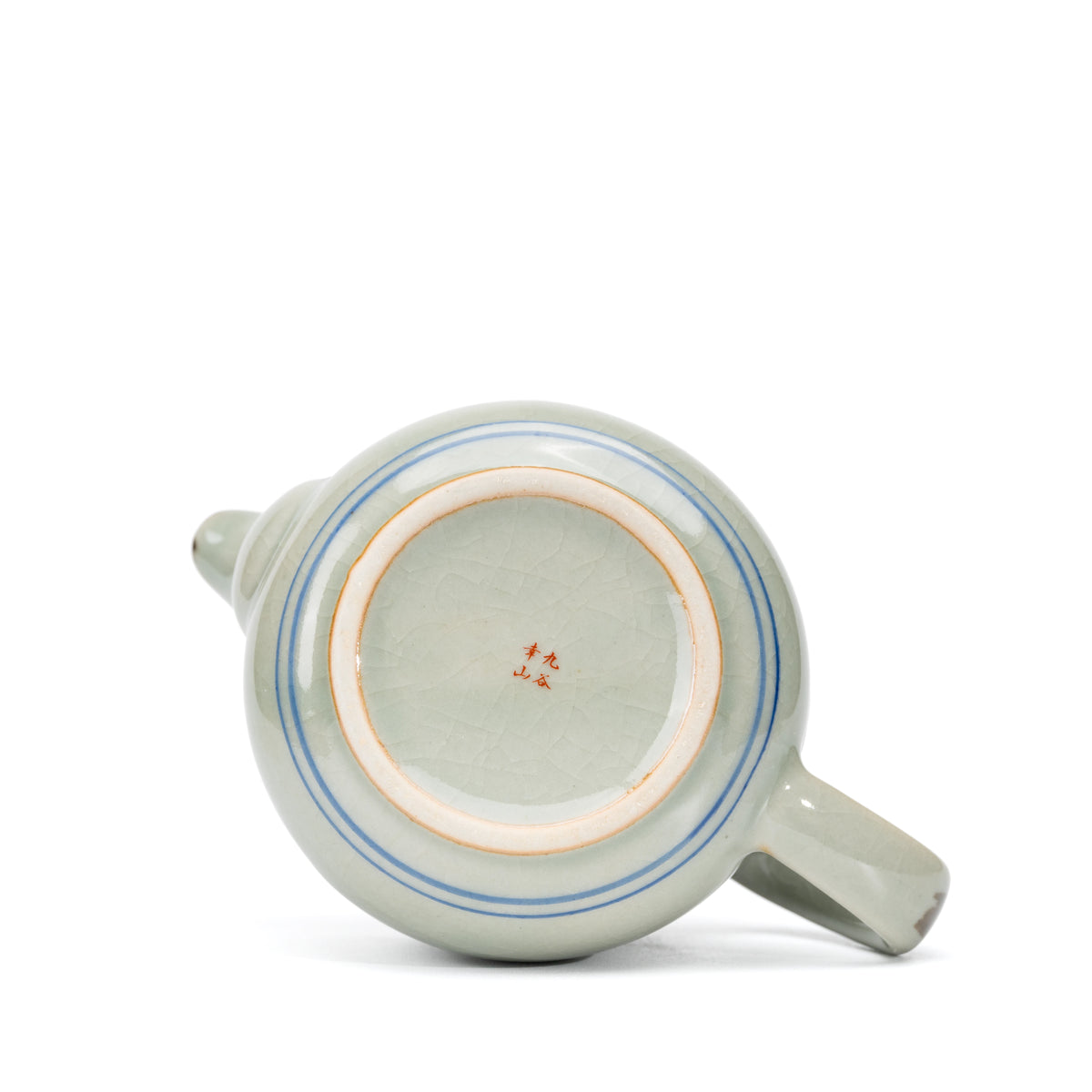 Underside of the teapot with two blue rings and a red maker's mark.