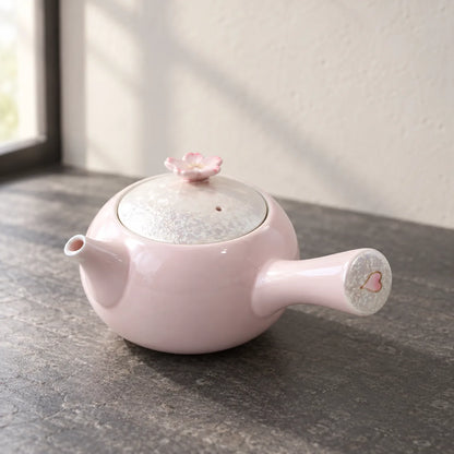 Tasei pink sakura side-handle kyusu showing its blossom lid knob and heart-painted handle end