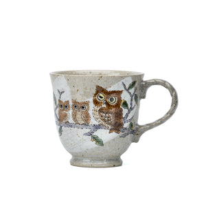 Front view of a Kutani ceramic mug decorated with three owls on a branch.