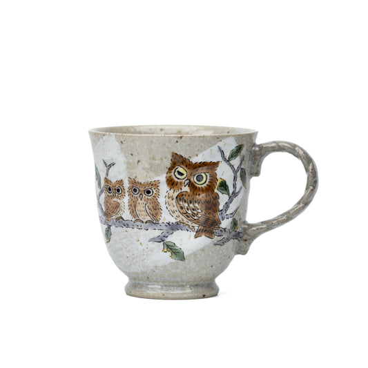 Front view of a Kutani ceramic mug decorated with three owls on a branch.