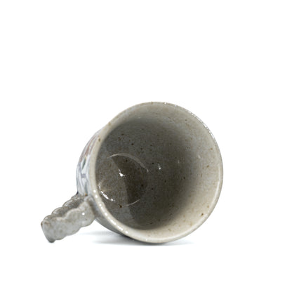 Kutani three owls mug tilted to show its glazed interior.