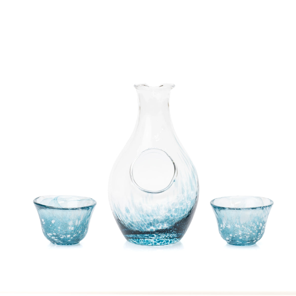 Front view of the glass carafe's round ice pocket and two blue cups.