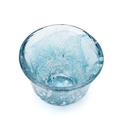 Overhead view into a blue glass sake cup.