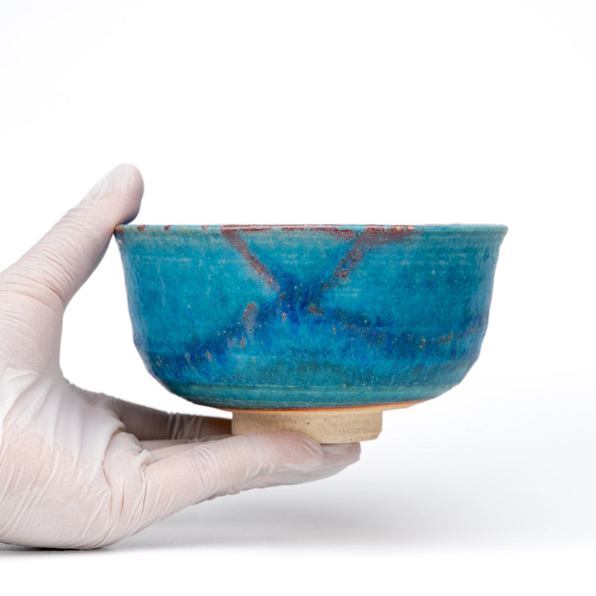 Blue matcha bowl held in a gloved hand.