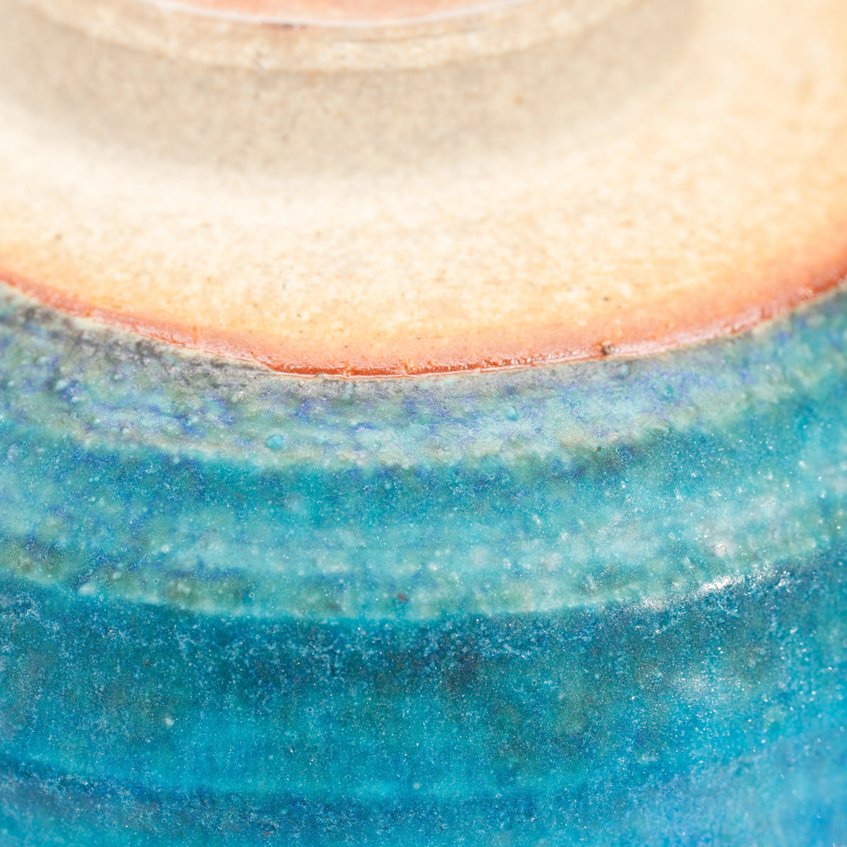 Warm unglazed clay above the blue glazed bowl's foot.