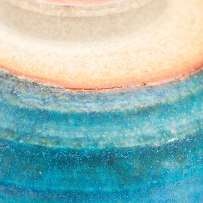 Warm unglazed clay above the blue glazed bowl's foot.