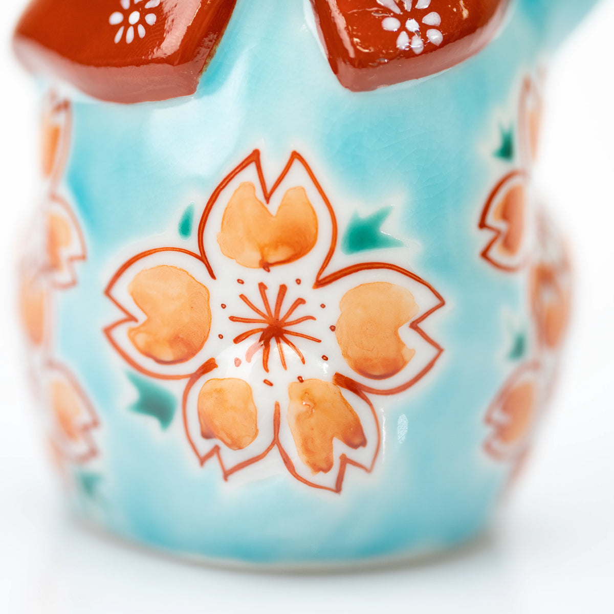 Cherry blossom decoration on the turquoise cat's back.
