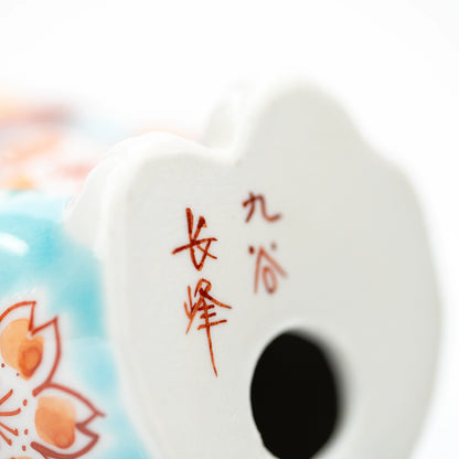 Red maker's inscription and opening on the turquoise cat's underside.