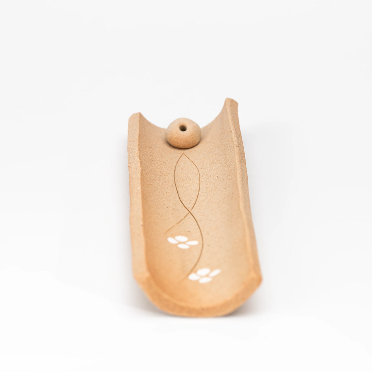 Angled top view of the brown incense tray without an incense stick.
