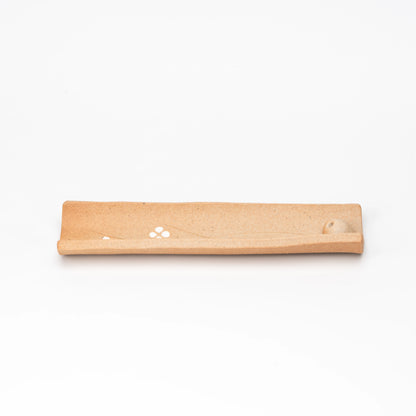 Brown floral incense tray shown from above.