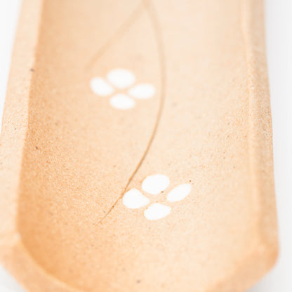 Close-up of white four-petalled flowers on the brown incense tray.