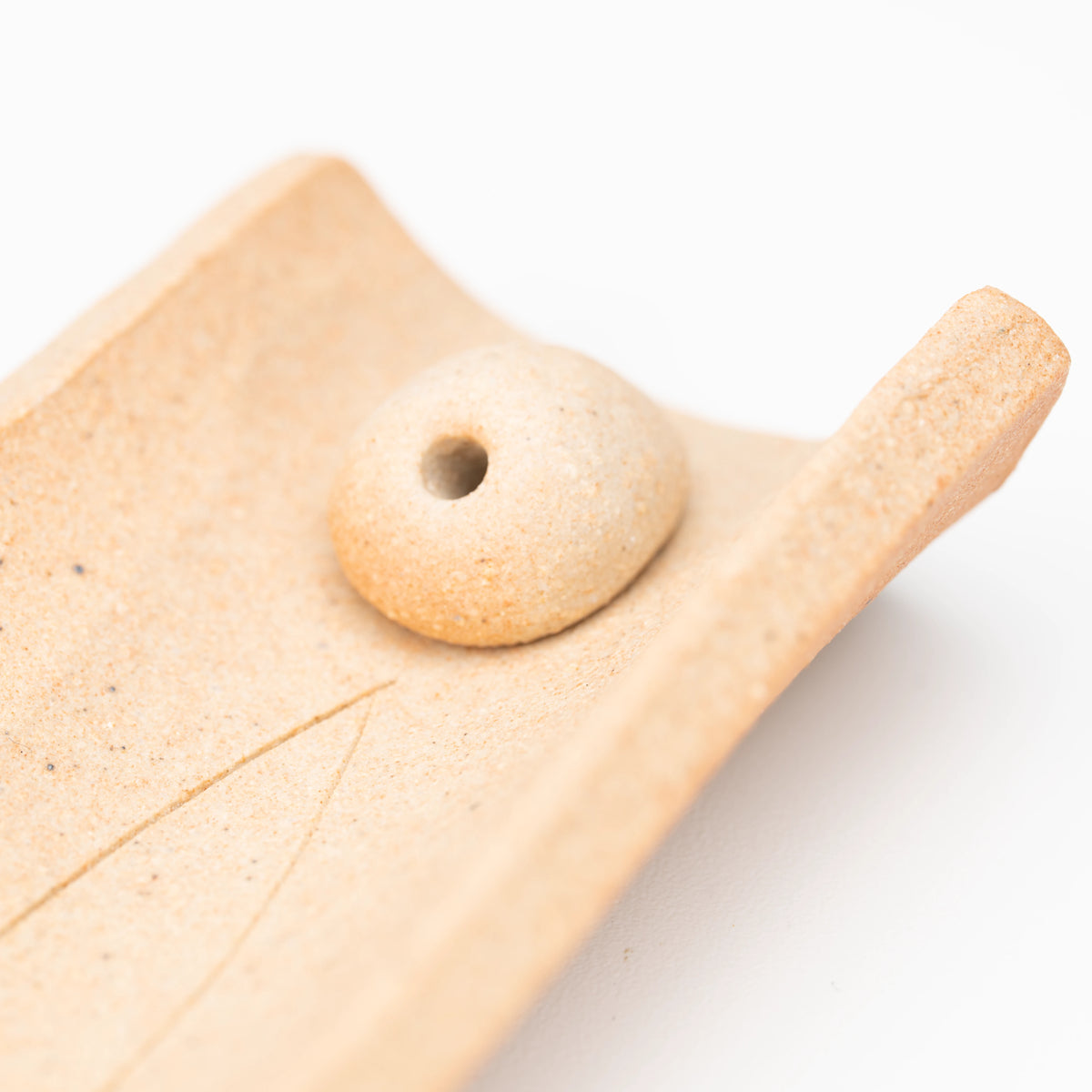 Close-up of the rounded incense insert and its stick hole.